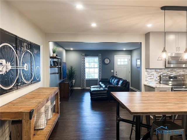 dining space featuring dark wood-type flooring, recessed lighting, and baseboards