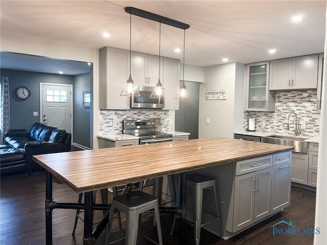 kitchen with stainless steel appliances, a sink, wooden counters, and gray cabinetry