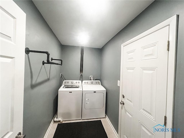 washroom with baseboards, laundry area, and washer and dryer