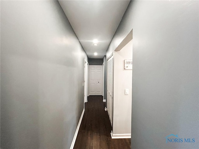 hallway with dark wood-style floors and baseboards