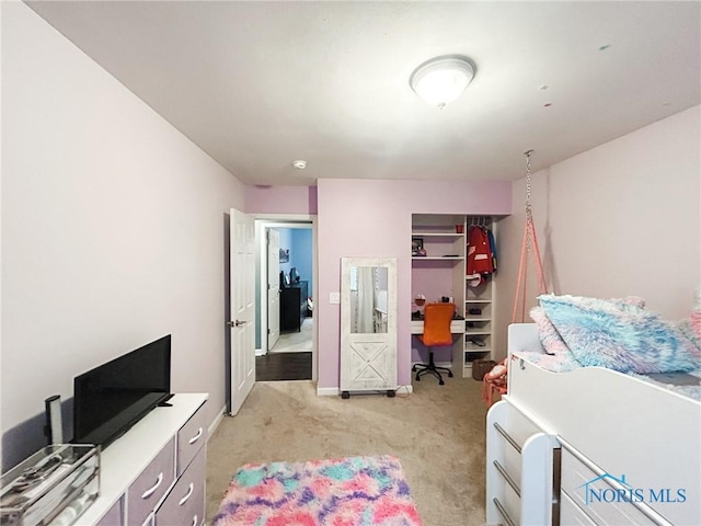 bedroom with baseboards, a closet, and light colored carpet