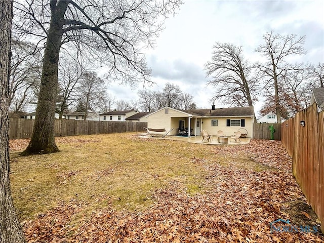 back of house with a patio, a yard, and a fenced backyard