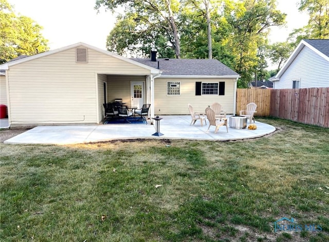 back of property featuring a yard, fence, and a patio