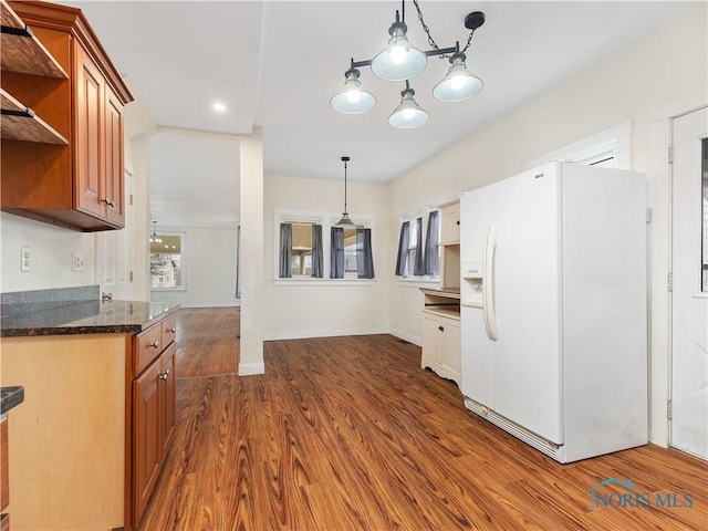 kitchen with white refrigerator with ice dispenser, dark wood finished floors, brown cabinets, hanging light fixtures, and open shelves