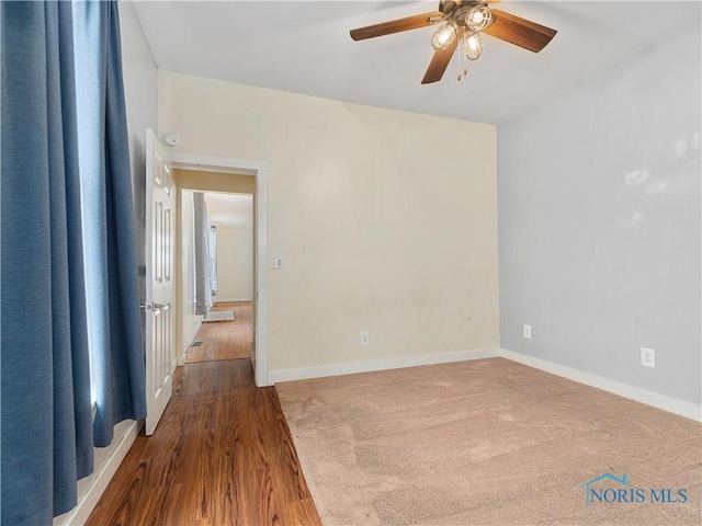 spare room with ceiling fan, baseboards, and wood finished floors