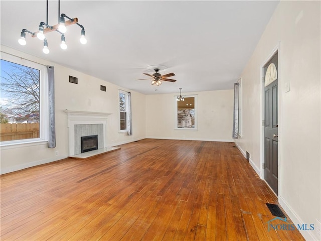 unfurnished living room featuring wood-type flooring, a fireplace, and visible vents