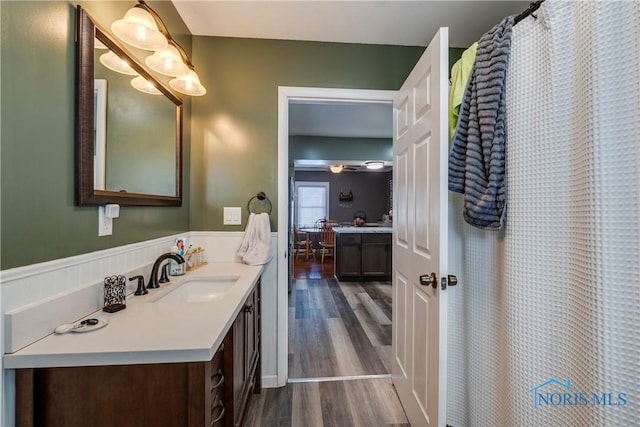 bathroom featuring a shower with shower curtain, ensuite bathroom, wood finished floors, and vanity