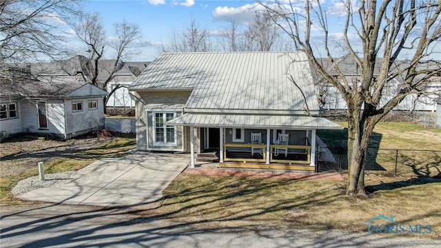 view of front of home featuring covered porch, metal roof, a front yard, and fence