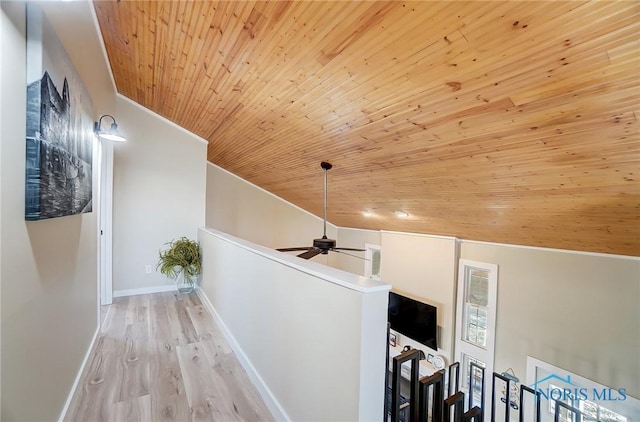 corridor with an upstairs landing, wooden ceiling, baseboards, and wood finished floors