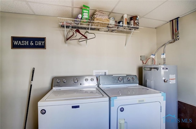 clothes washing area featuring laundry area, water heater, and washing machine and clothes dryer