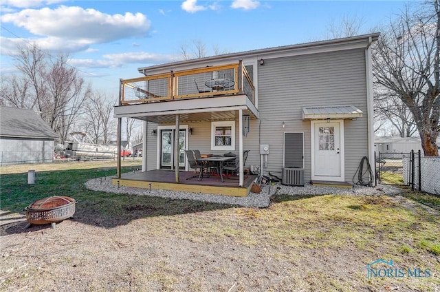 rear view of house featuring a fire pit, fence, cooling unit, a balcony, and a gate