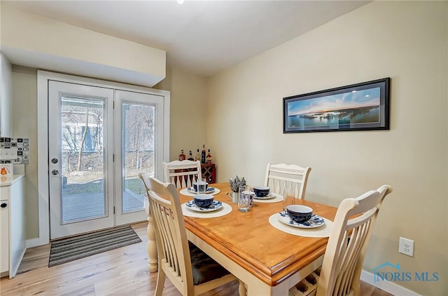 dining area with baseboards and light wood-style floors