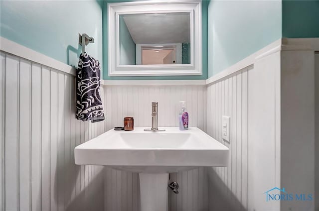 bathroom with a sink and a wainscoted wall