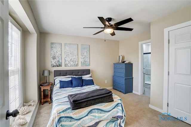 bedroom featuring baseboards, ensuite bathroom, carpet, and a ceiling fan