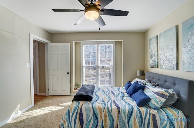 carpeted bedroom featuring baseboards and ceiling fan