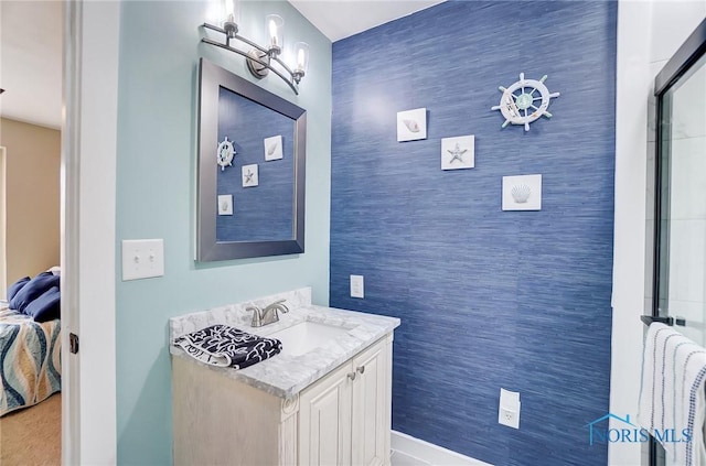 ensuite bathroom featuring an accent wall, vanity, and ensuite bathroom