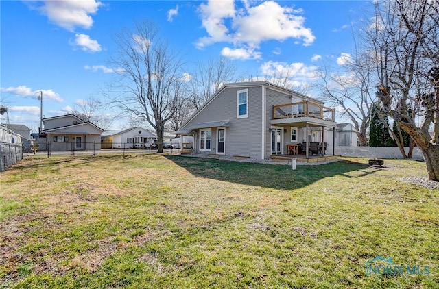 back of house featuring a patio, a lawn, a fenced backyard, and an outdoor fire pit