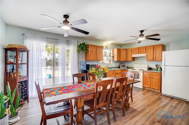 dining area with light wood-style flooring, a toaster, and a ceiling fan