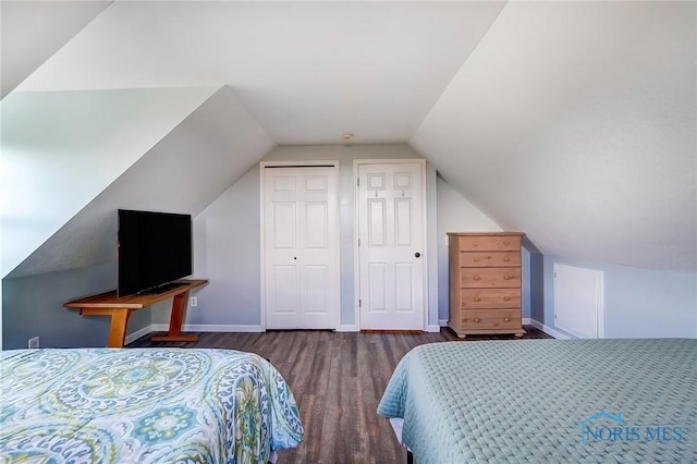 bedroom featuring lofted ceiling, a closet, wood finished floors, and baseboards