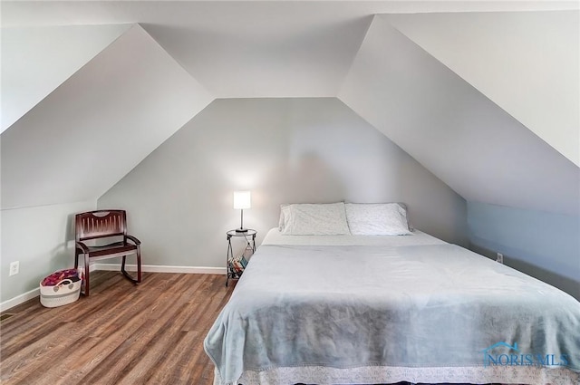 bedroom with baseboards, vaulted ceiling, and wood finished floors