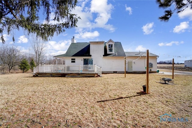 rear view of property with a deck, crawl space, a chimney, and a fire pit