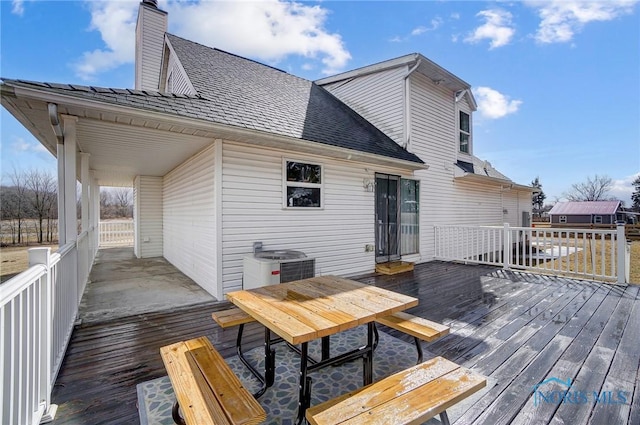 wooden deck with outdoor dining space and central air condition unit