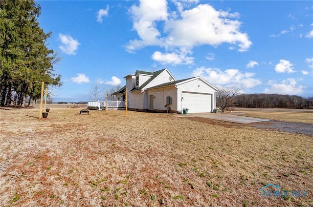 view of yard featuring concrete driveway and an attached garage