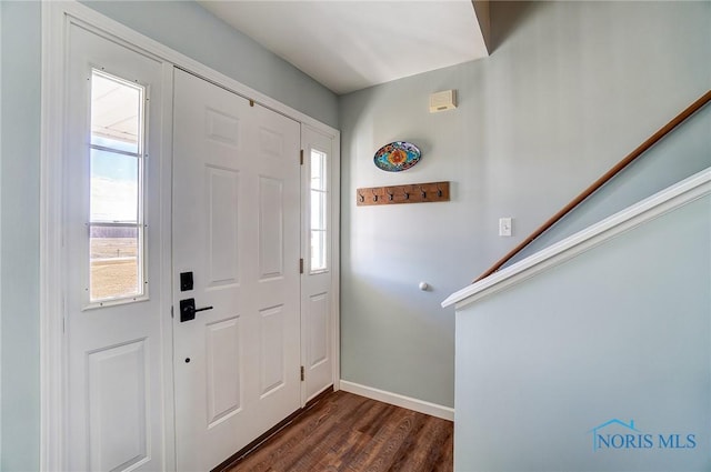 foyer featuring dark wood finished floors, stairway, and baseboards