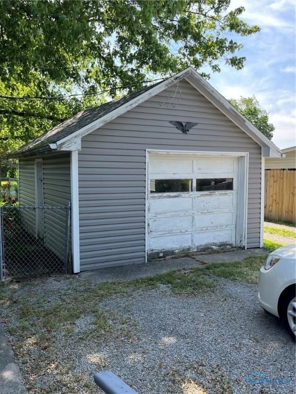 detached garage with driveway and fence