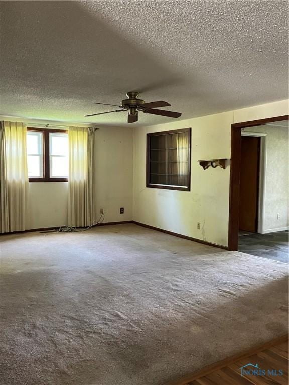 carpeted spare room featuring ceiling fan, a textured ceiling, and baseboards