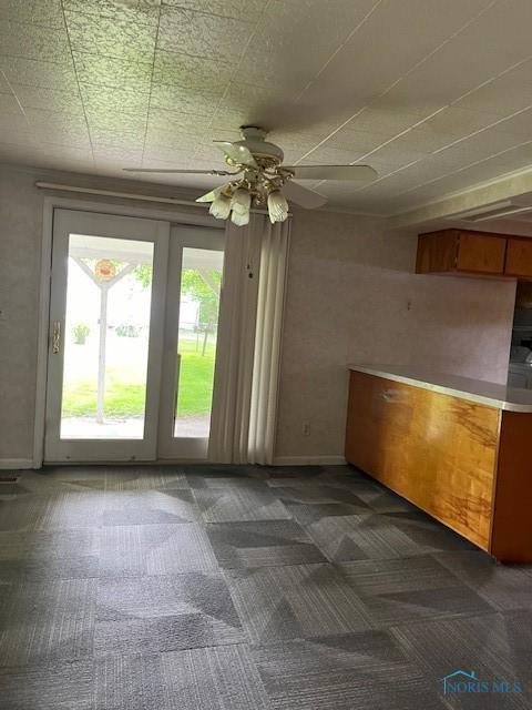 spare room featuring ceiling fan, carpet floors, and baseboards