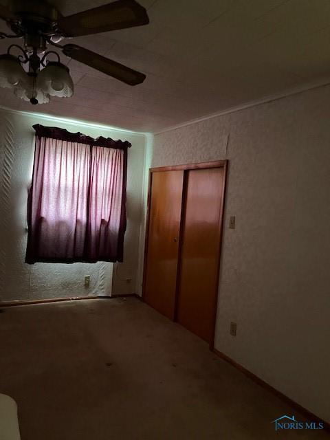 unfurnished bedroom featuring carpet floors, a ceiling fan, and a closet