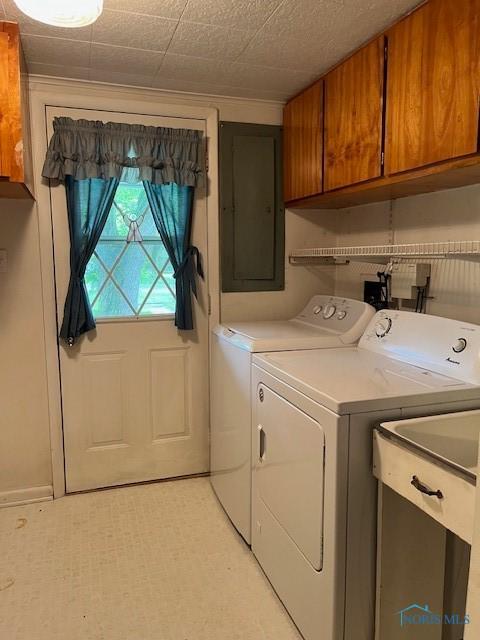 laundry room with light floors, separate washer and dryer, cabinet space, and electric panel