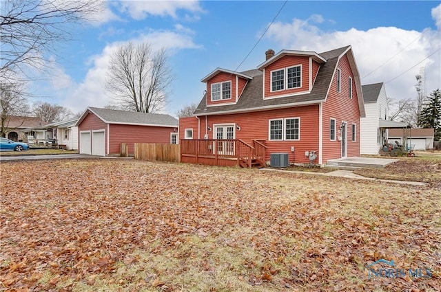 view of front of house with a deck, cooling unit, a shingled roof, an outdoor structure, and a detached garage