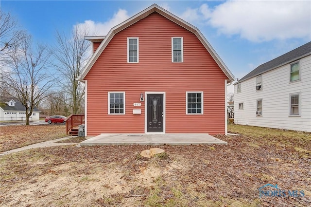 rear view of house featuring a patio area and a gambrel roof