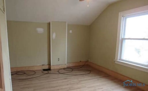 additional living space featuring a ceiling fan, vaulted ceiling, baseboards, and wood finished floors