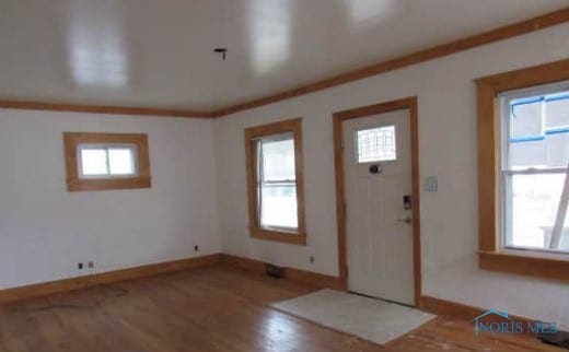 foyer entrance featuring baseboards, ornamental molding, and wood finished floors