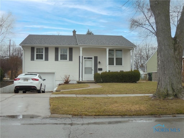 bi-level home with an attached garage, a front lawn, concrete driveway, and roof with shingles