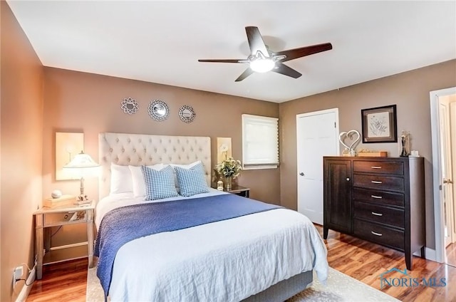 bedroom featuring ceiling fan, light wood-style flooring, and baseboards