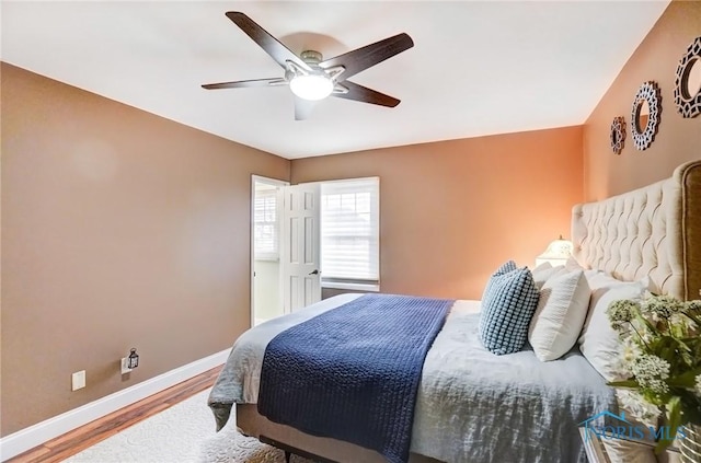 bedroom with ceiling fan, baseboards, and wood finished floors