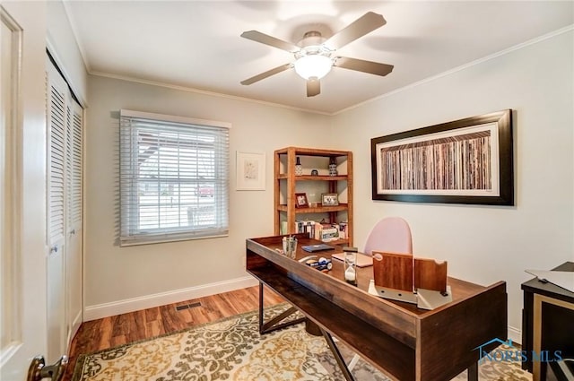 home office featuring visible vents, ornamental molding, ceiling fan, wood finished floors, and baseboards