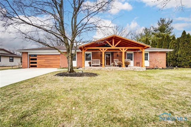 view of front of home with an attached garage, a front lawn, concrete driveway, and brick siding