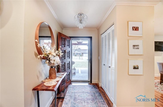 doorway to outside featuring ornamental molding, dark wood finished floors, baseboards, and an inviting chandelier