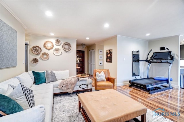 living area featuring recessed lighting, baseboards, crown molding, and light wood finished floors