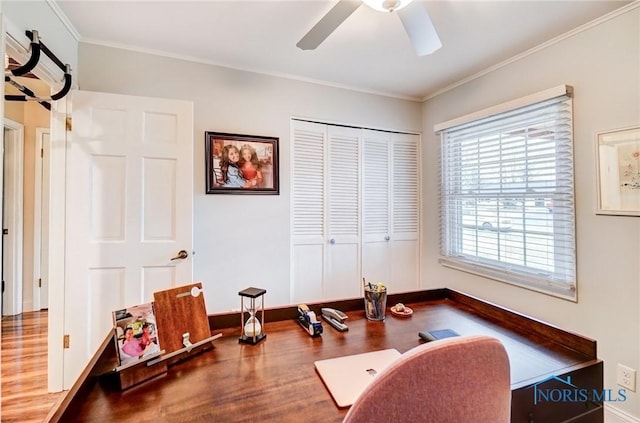 office space with baseboards, a ceiling fan, crown molding, and wood finished floors