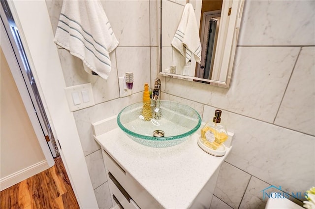 bathroom with wood finished floors, vanity, and baseboards