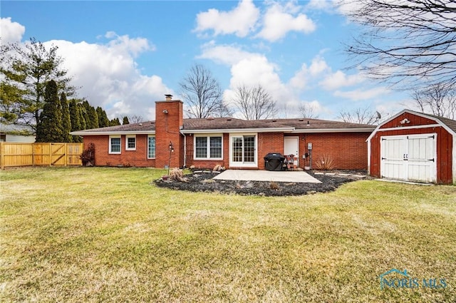 rear view of property featuring a patio, a chimney, fence, a shed, and an outdoor structure