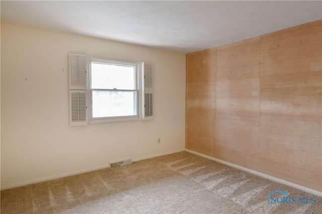 carpeted empty room featuring visible vents and baseboards