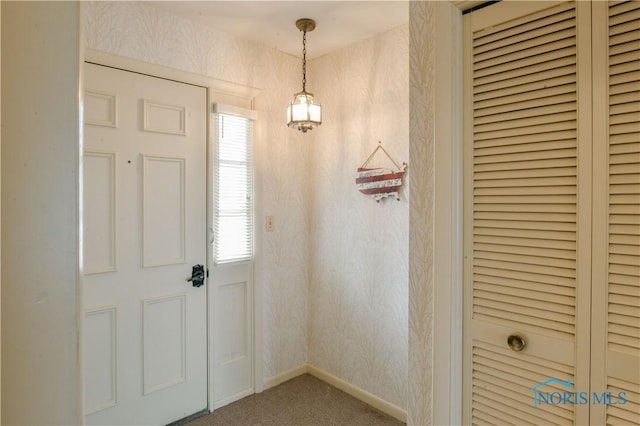 foyer featuring carpet flooring, baseboards, and wallpapered walls