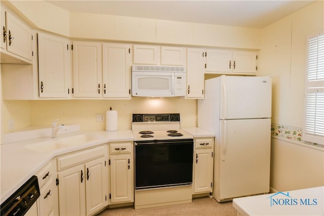 kitchen with white appliances, light countertops, a sink, and white cabinets